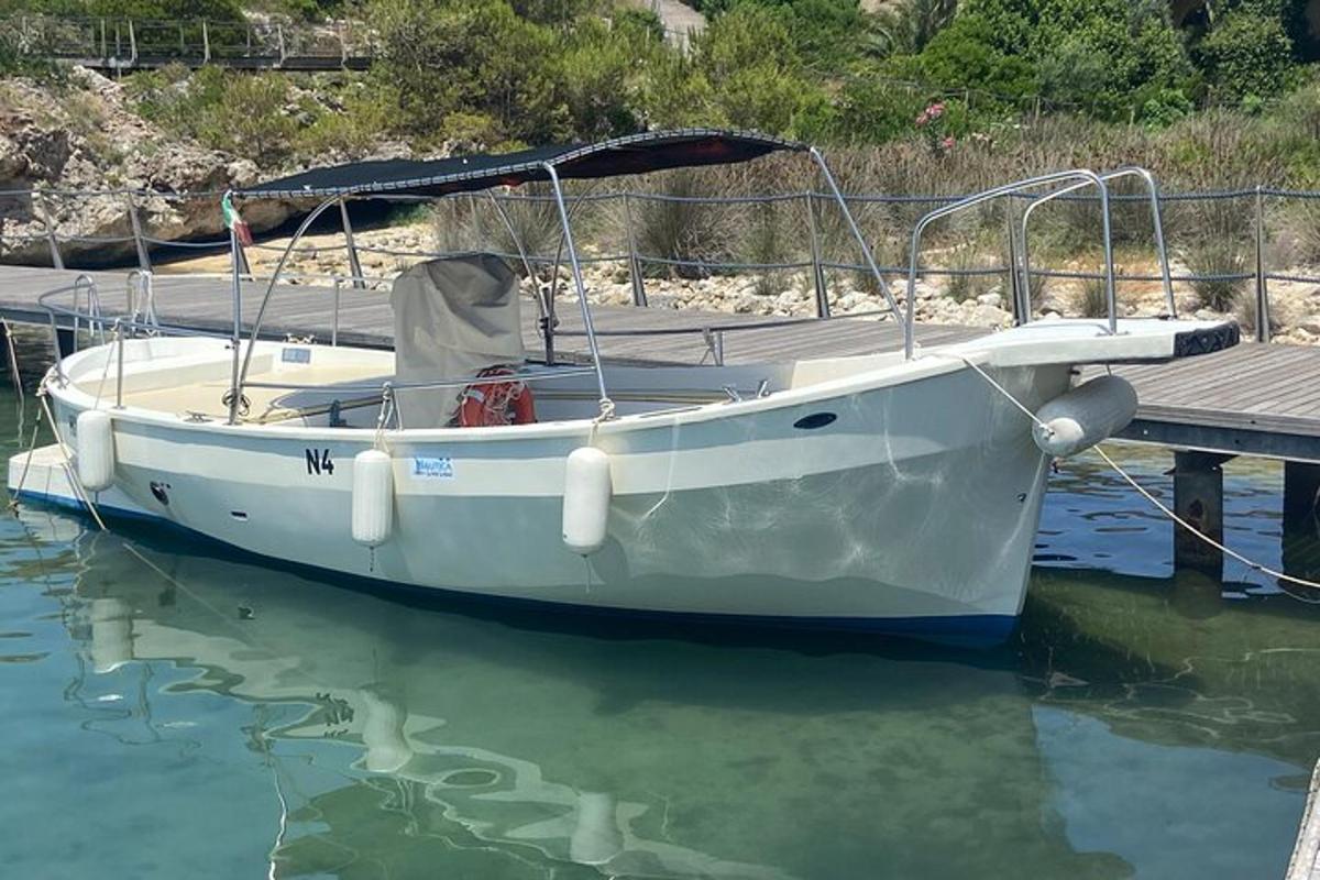 a white boat tied to a dock in the water