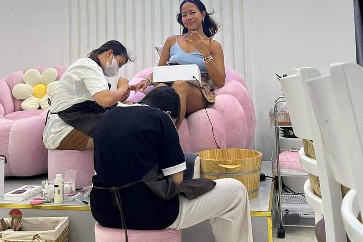dues dones en una perruqueria amb un home assegut en una cadira rosa