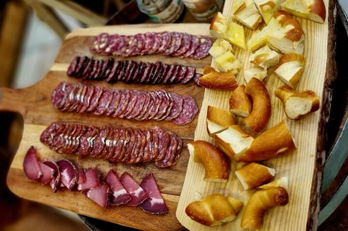 a wooden cutting board with sausages and apples on it