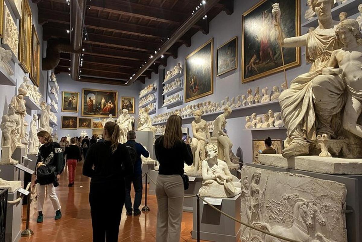 un gruppo di persone che camminano in un museo con statue