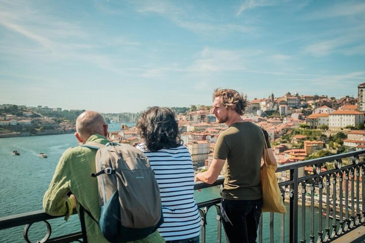 tre persone in piedi su un balcone che guardano la città