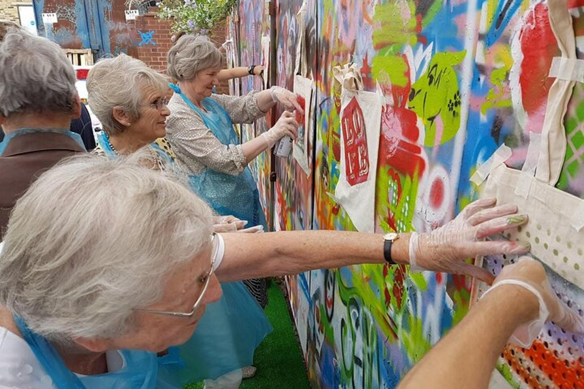 un grup de dones grans dretes al costat d'una paret