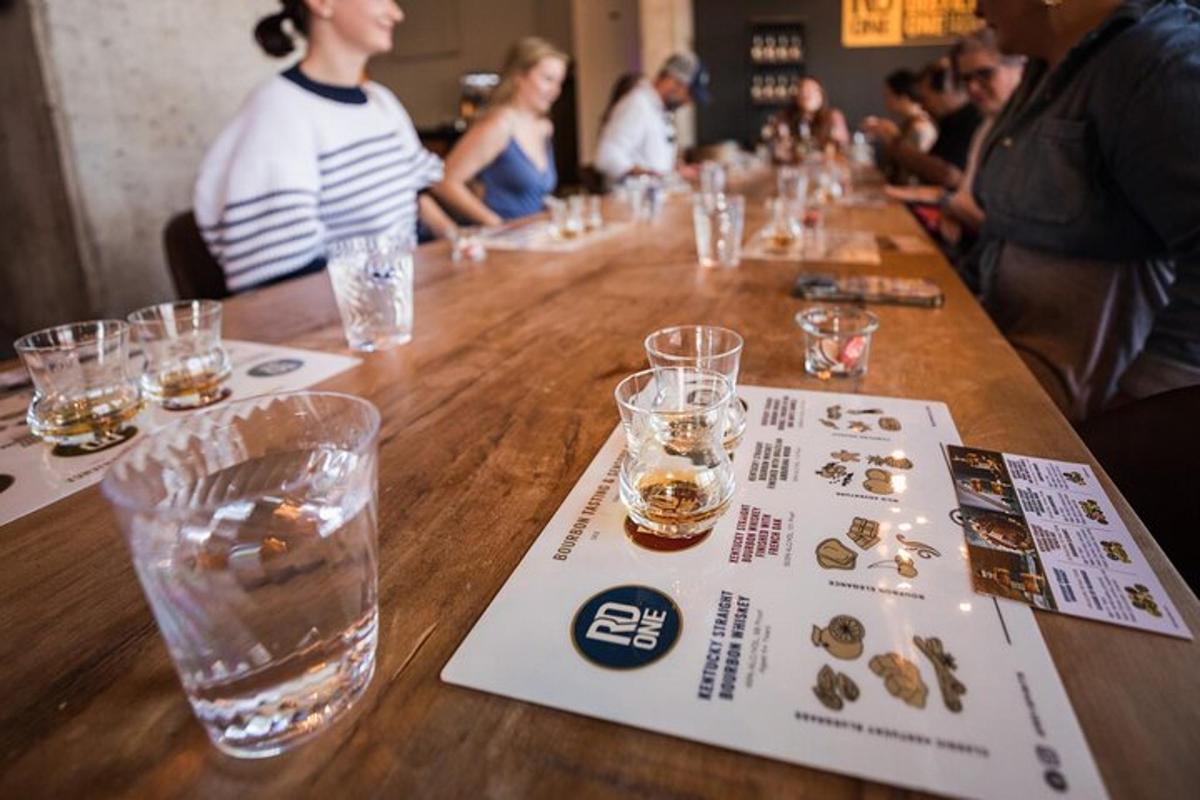 a long wooden table with glasses and a menu