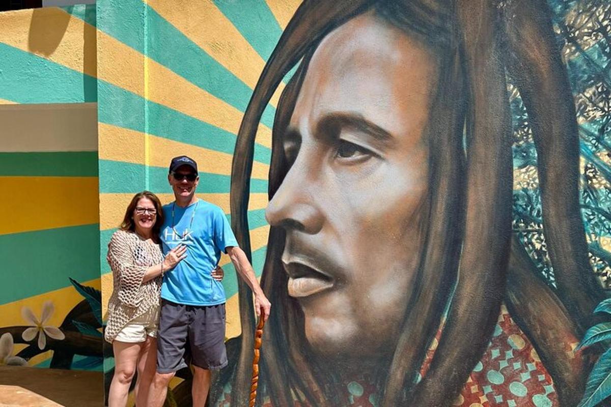 un uomo e una donna in piedi davanti a un grande murale