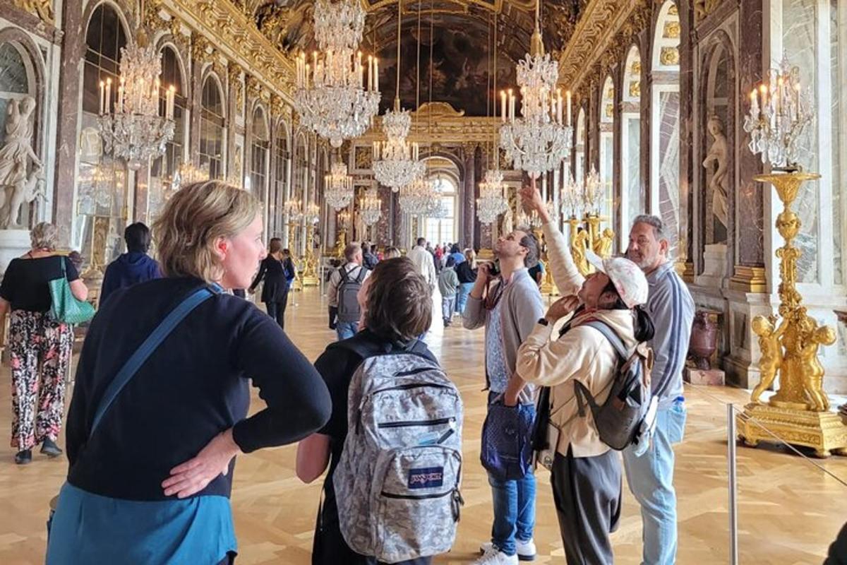 a group of people standing in a large room with chandeliers