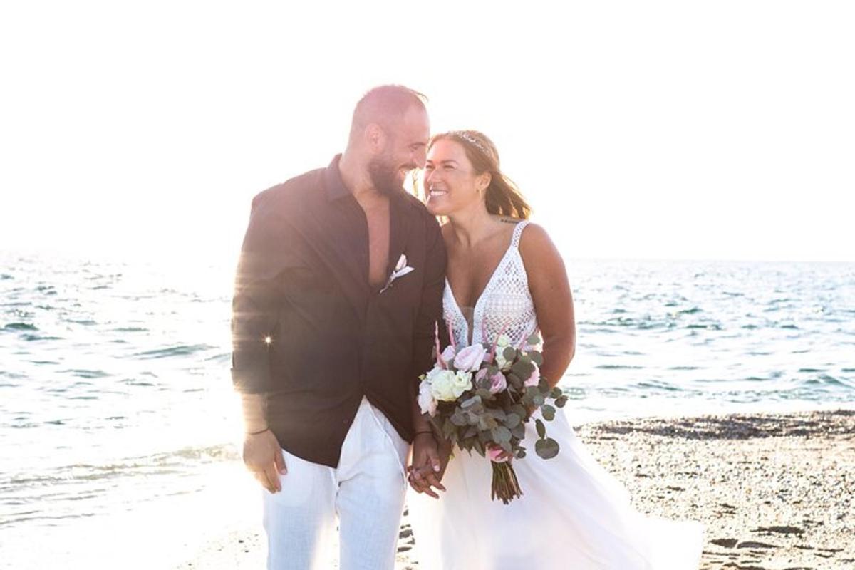 Una novia y un novio posando para una foto en la playa