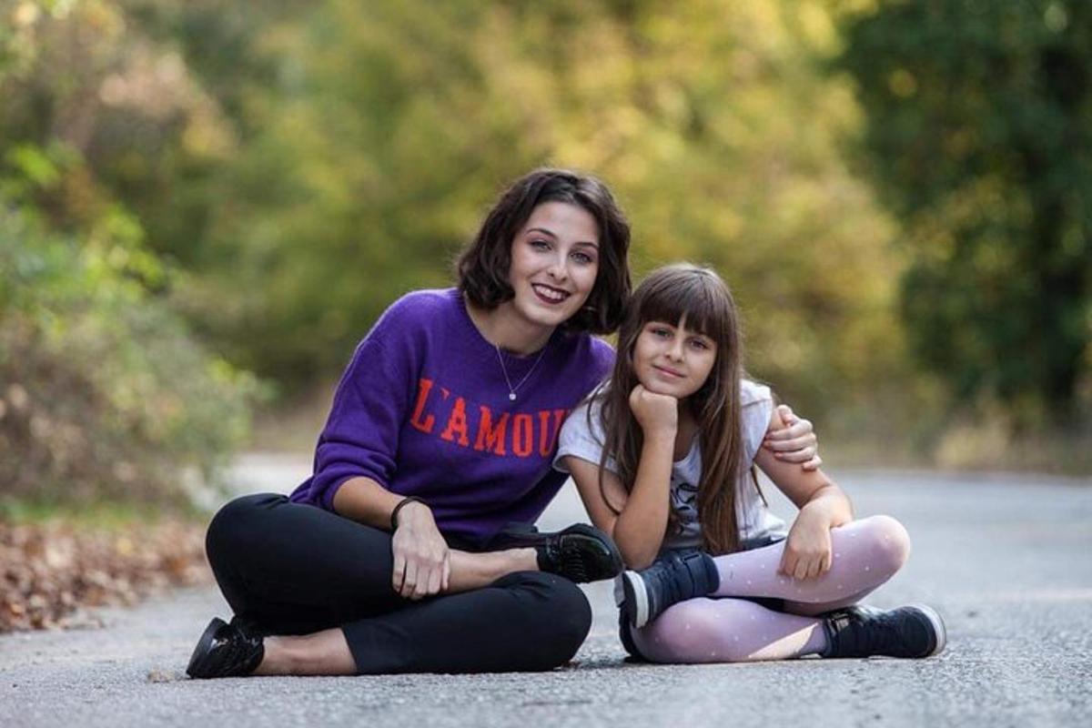 Dos niñas sentadas en el suelo en una carretera