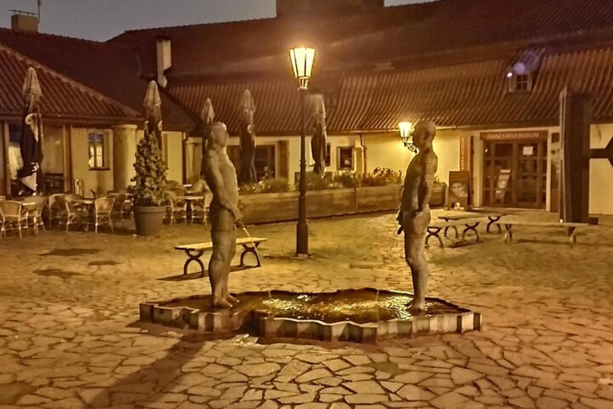 dua patung orang berdiri di halaman pada malam hari