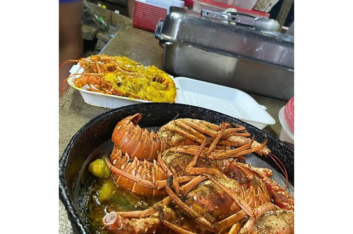 Una sartén con langostas asadas y otros alimentos en un mostrador.