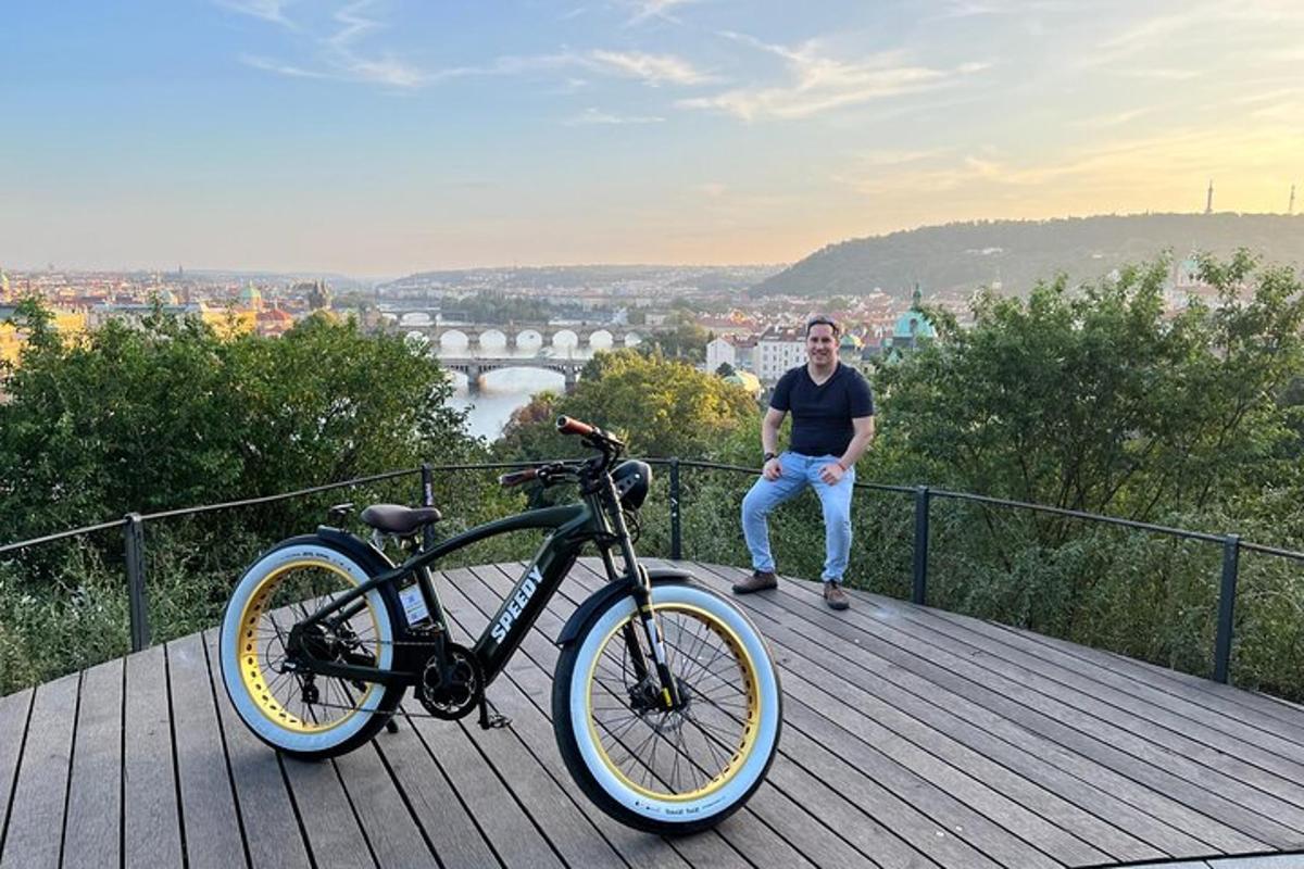 un uomo seduto accanto a una bicicletta su un ponte di legno