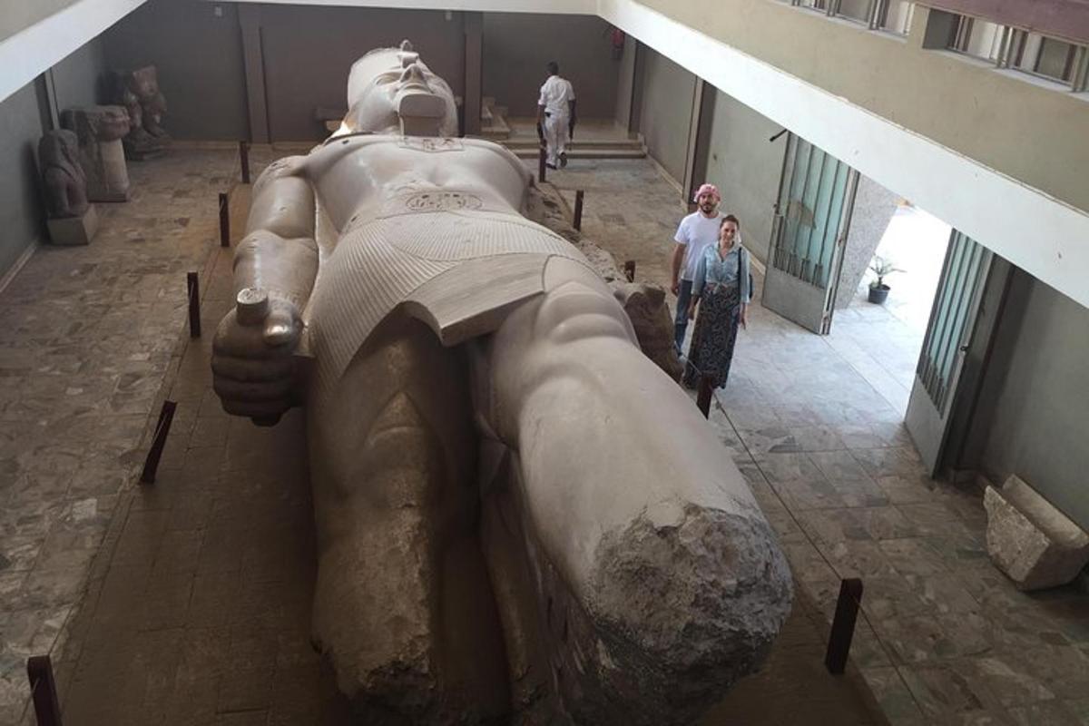 Una estatua en un museo con dos personas mirándola.