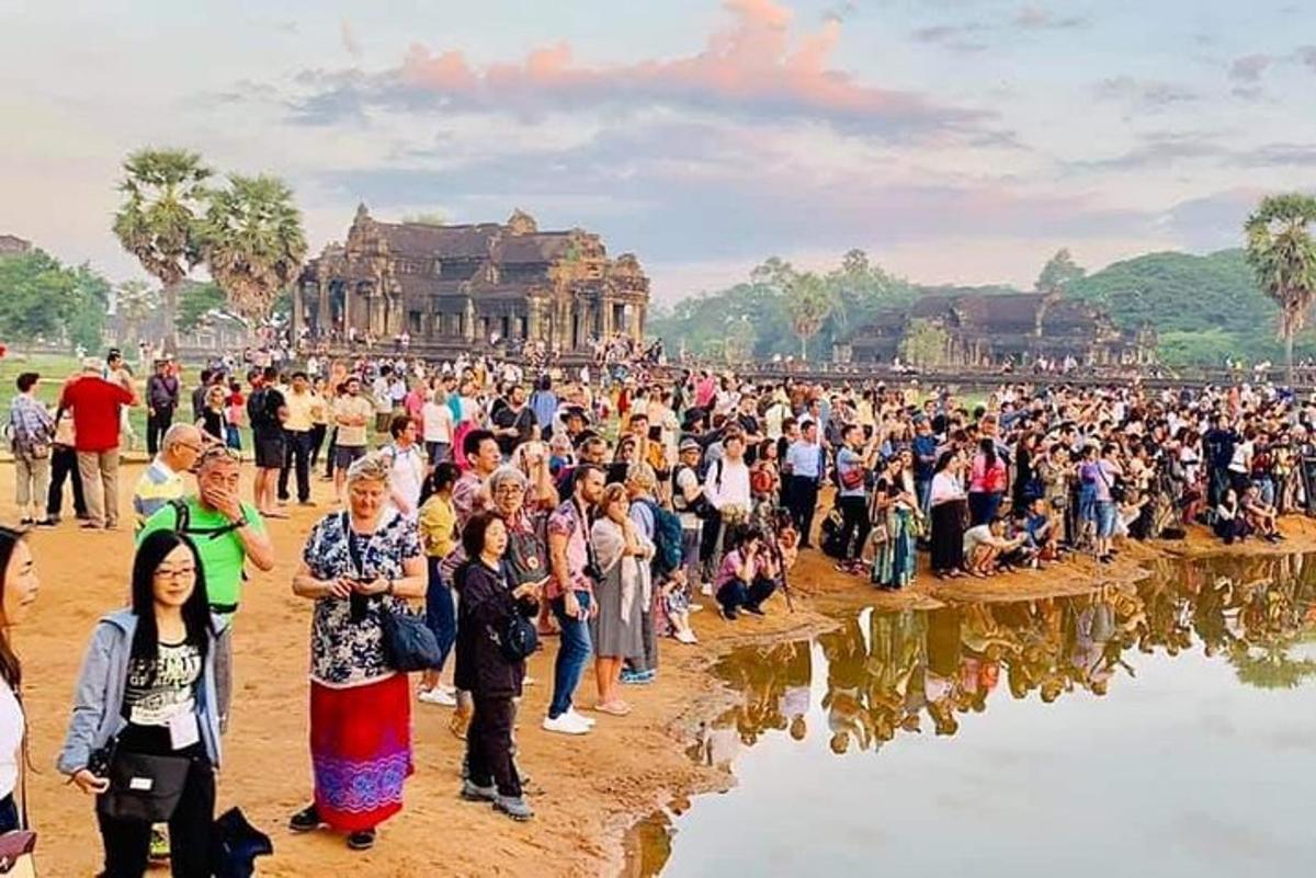 Una gran multitud de personas de pie frente a un templo.