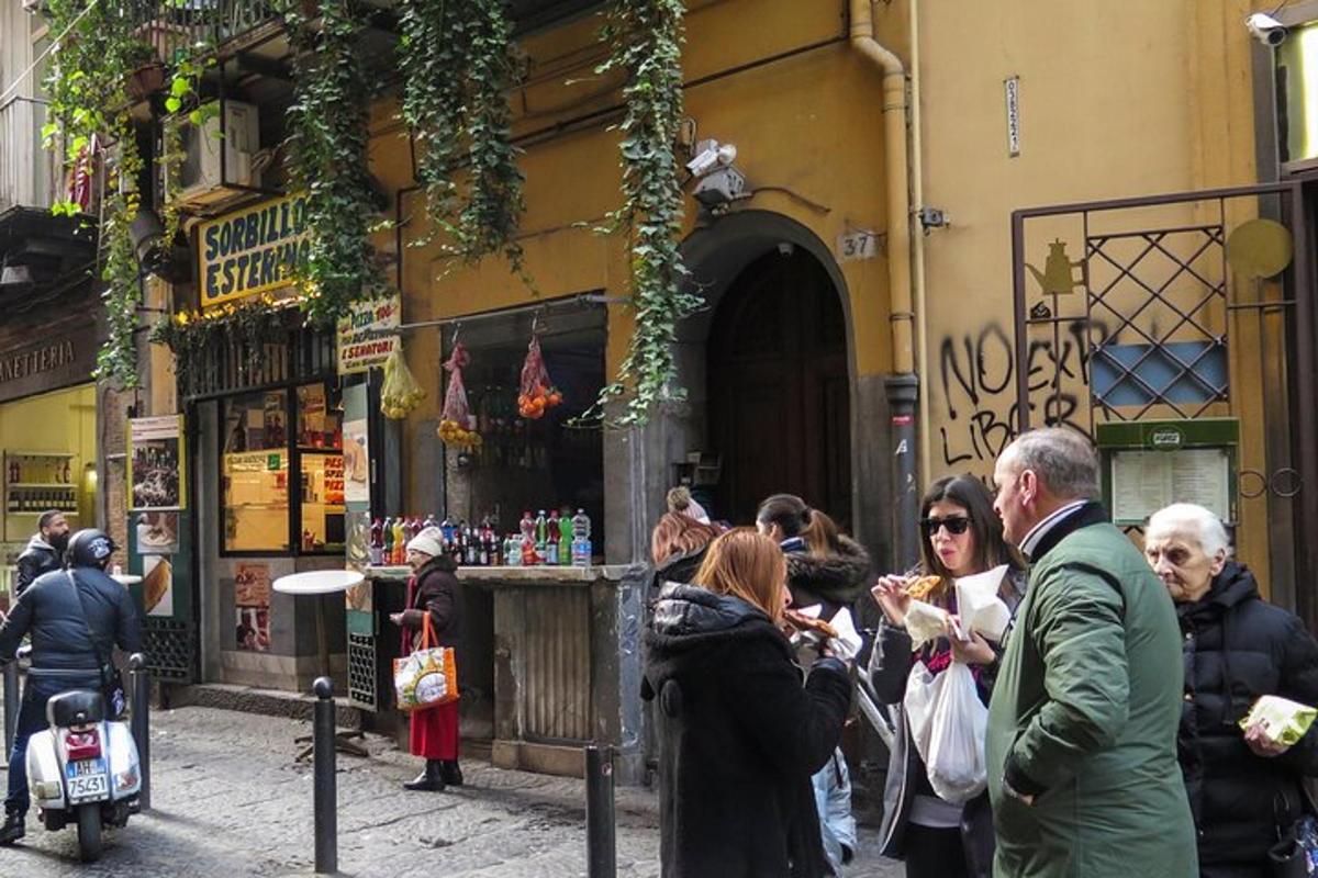 un gruppo di persone in piedi fuori da un edificio