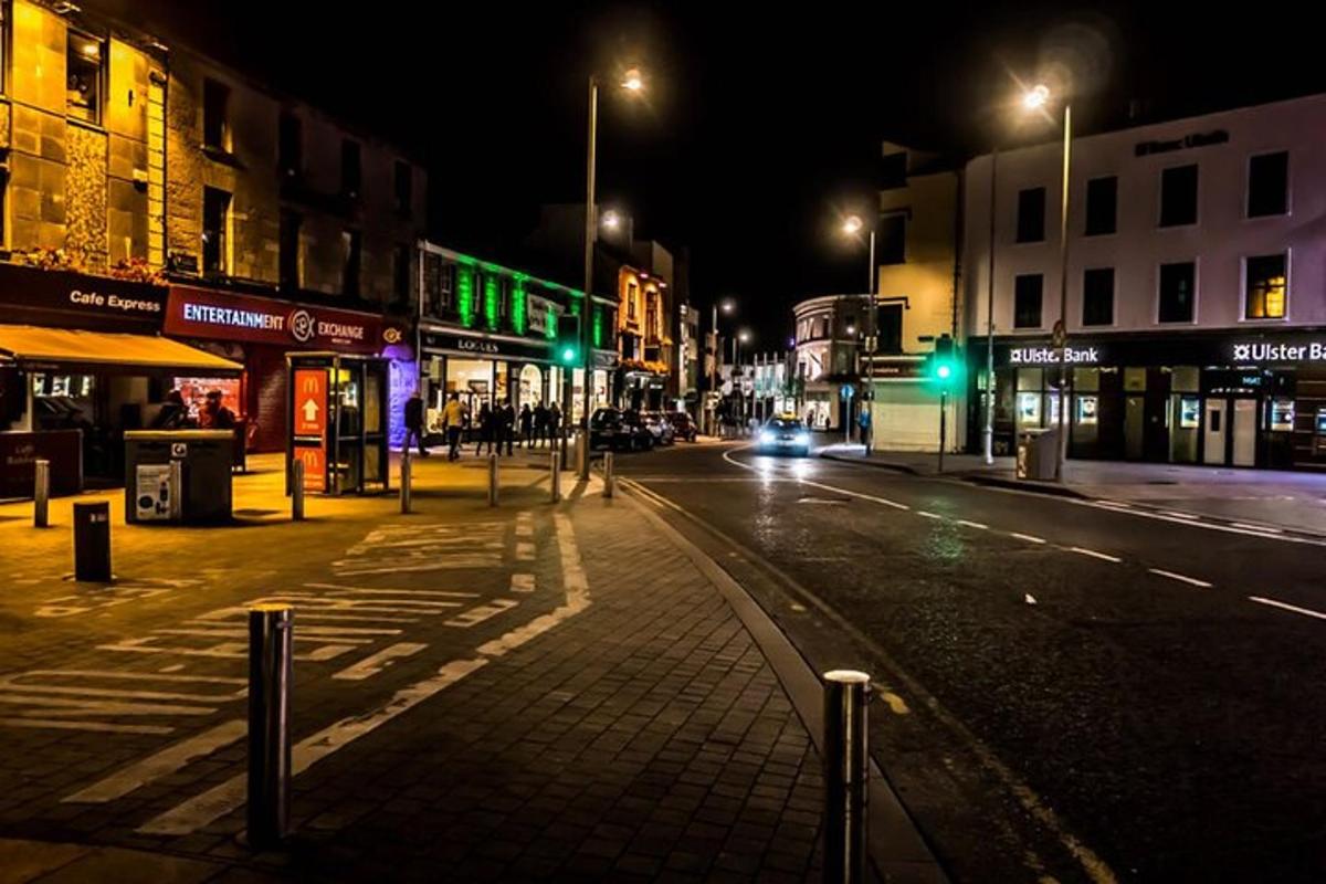 an empty city street at night with green lights