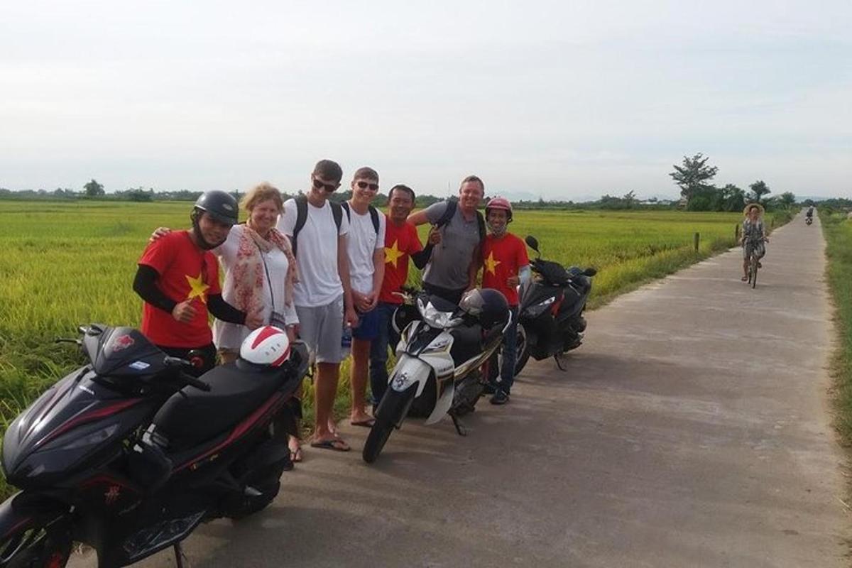 cilvēku grupa, kas stāv blakus motocikliem uz ceļa