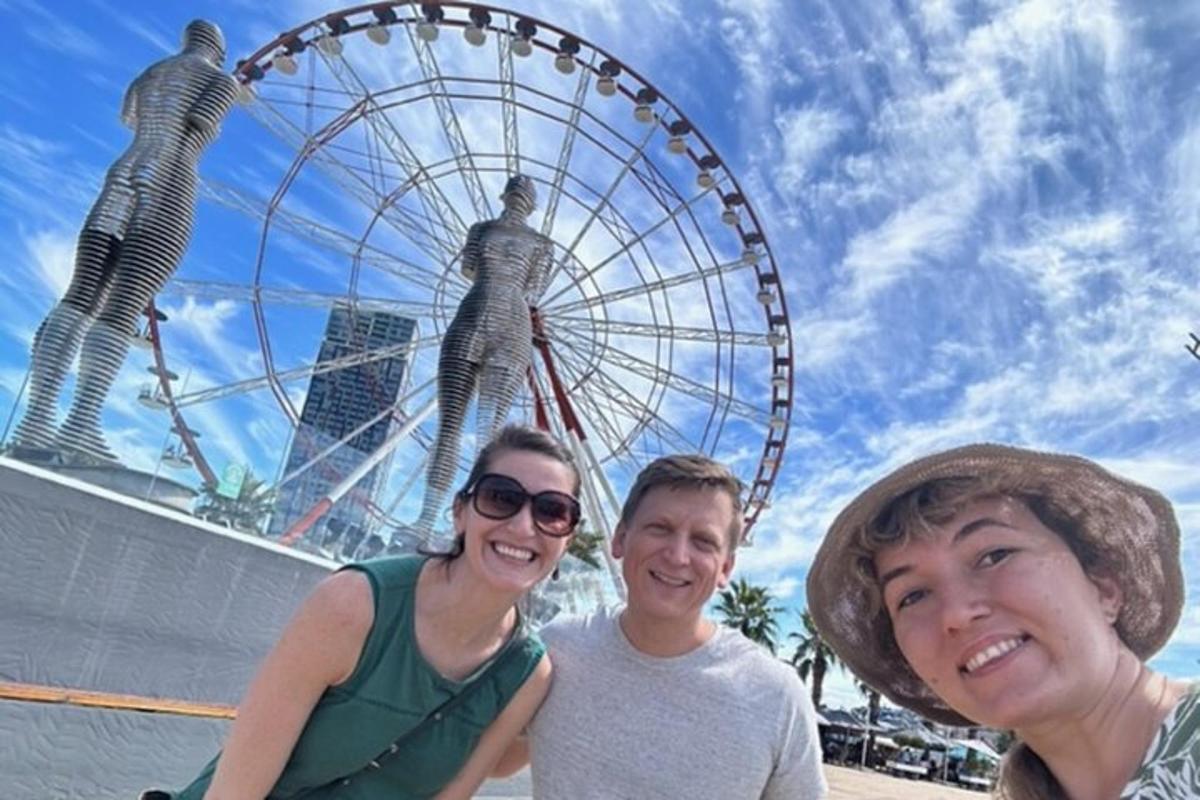 three people standing in front of a ferris wheel
