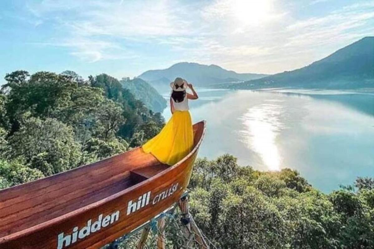 kona í gulum kjól stendur ofan á bát