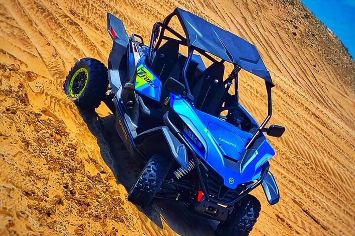 toprak bir tepeden aşağı doğru giden mavi bir ATV