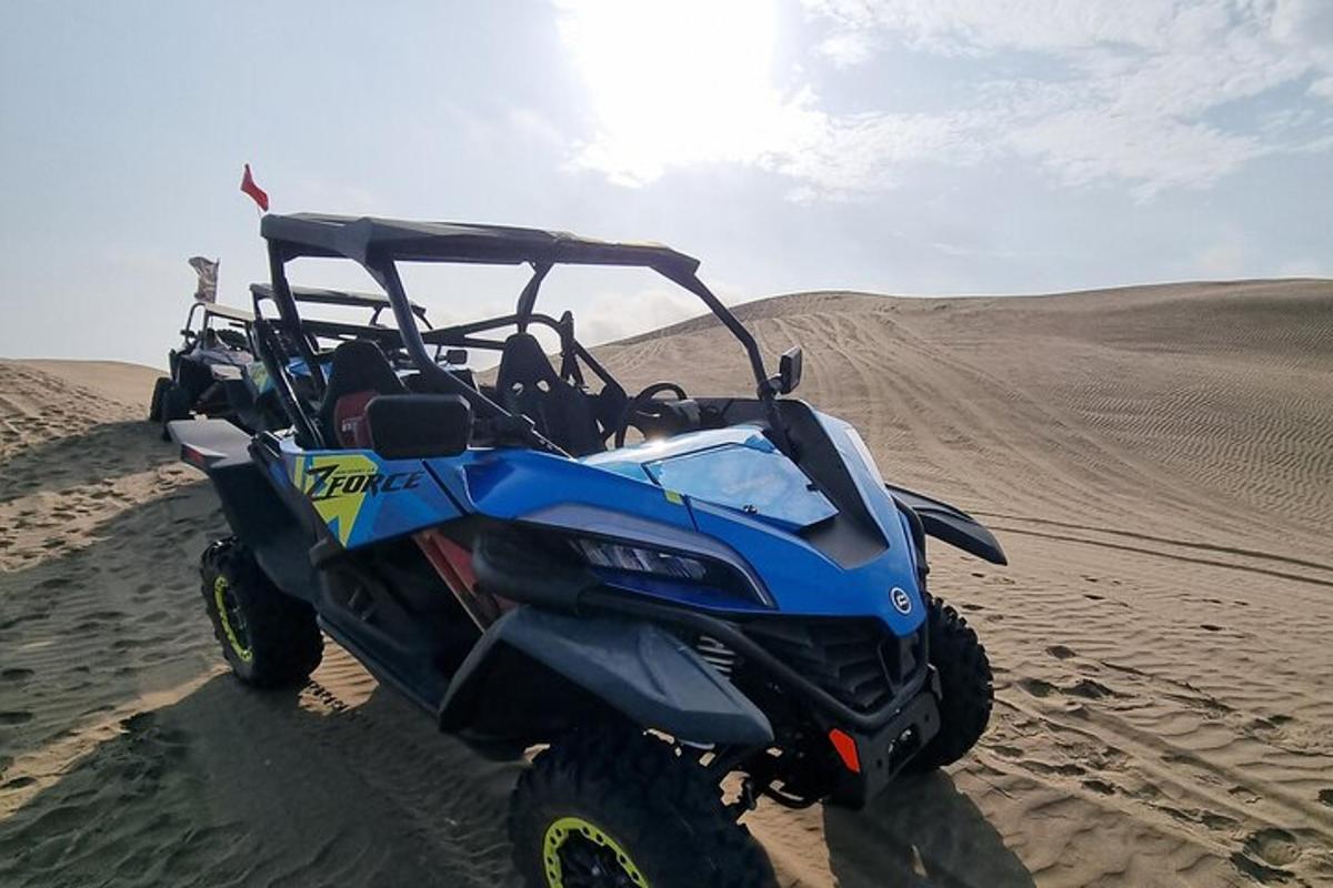 een blauwe ATV geparkeerd in het zand in de woestijn