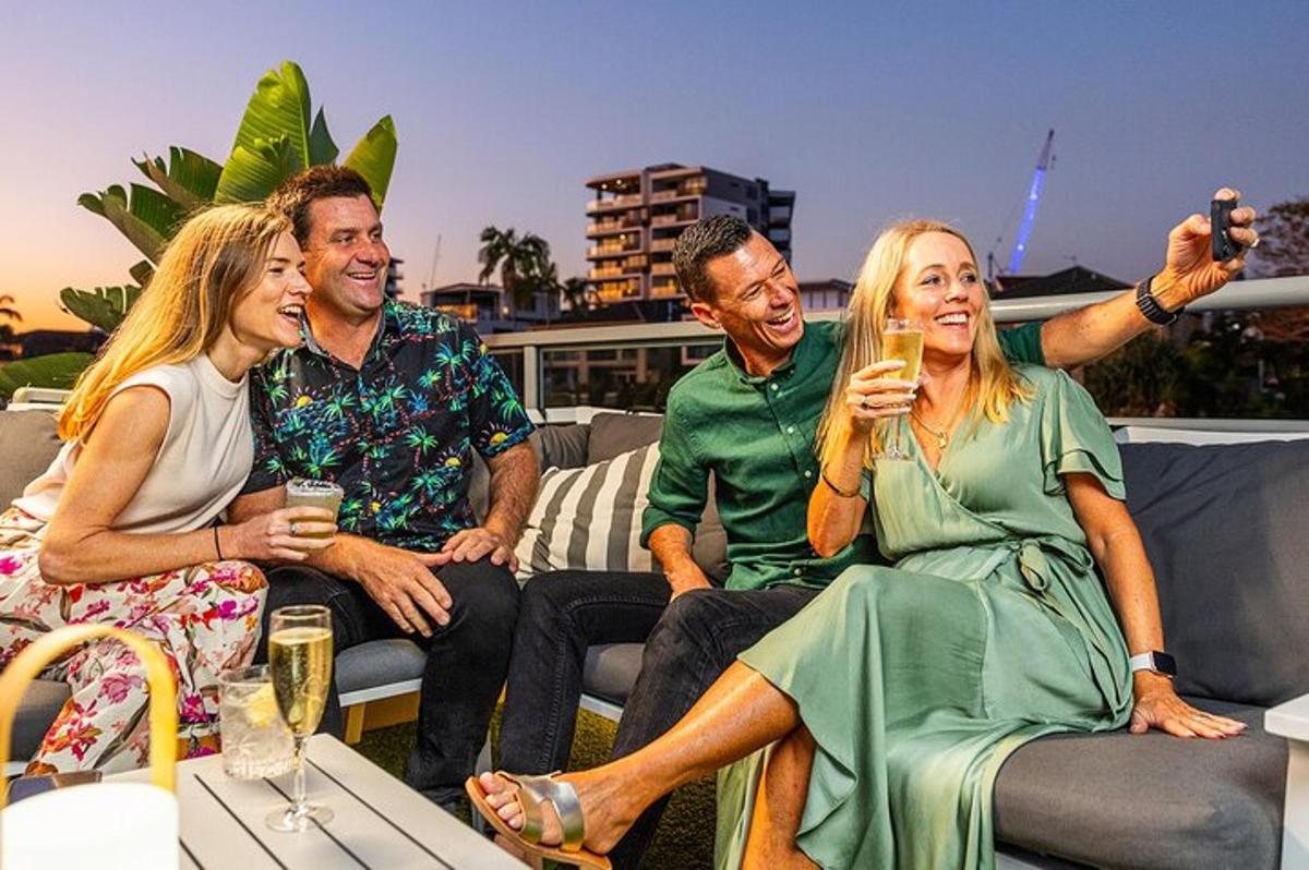 a group of people sitting on a rooftop drinking champagne