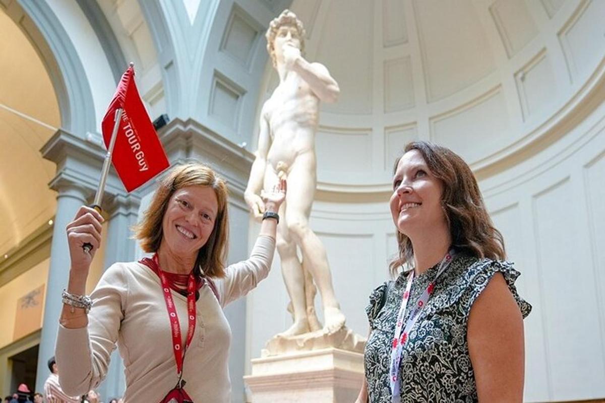 duas mulheres estão em pé em frente a uma estátua