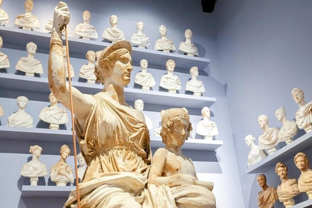 una estàtua davant de prestatgeries d'estàtues en un museu