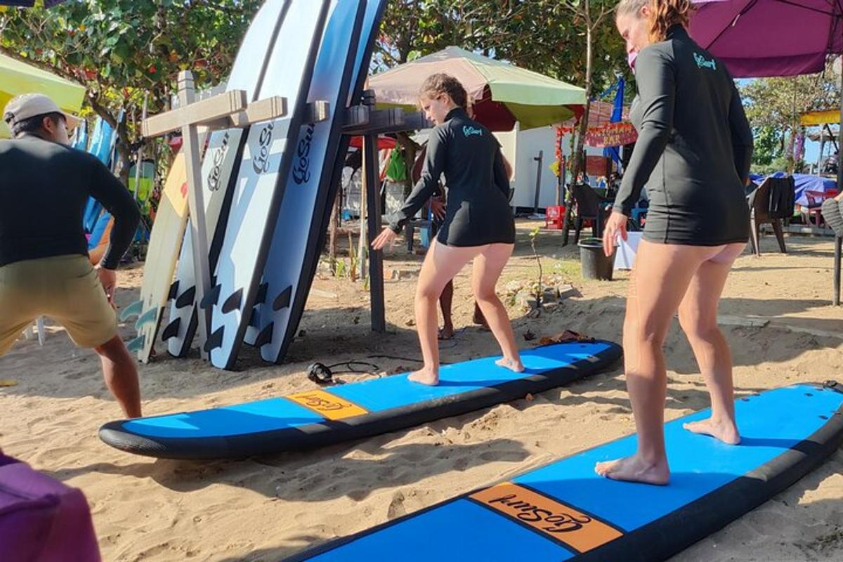 Dos mujeres de pie sobre una tabla de remo en la playa