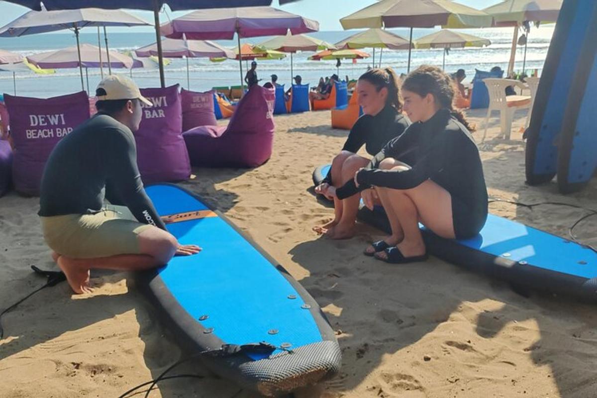 Un grupo de personas sentadas en tablas de surf en la playa.