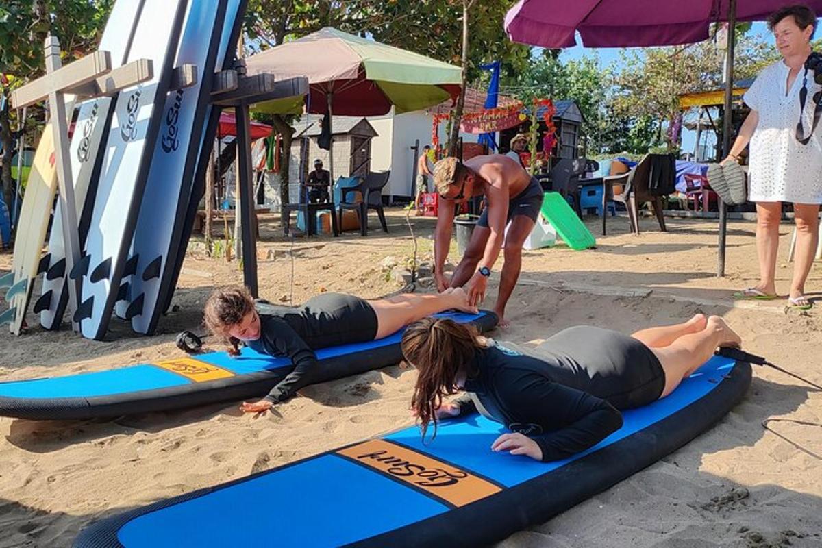 Un grupo de personas tumbadas sobre tablas de surf en la playa.