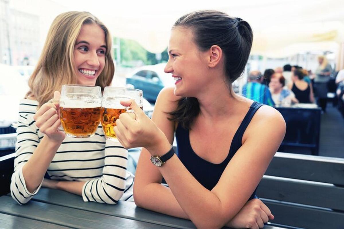dve ženski, ki sedita za mizo in pijeta pivo