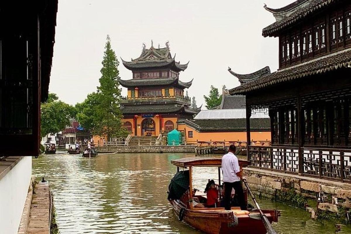 a man on a boat in a river in front of a building