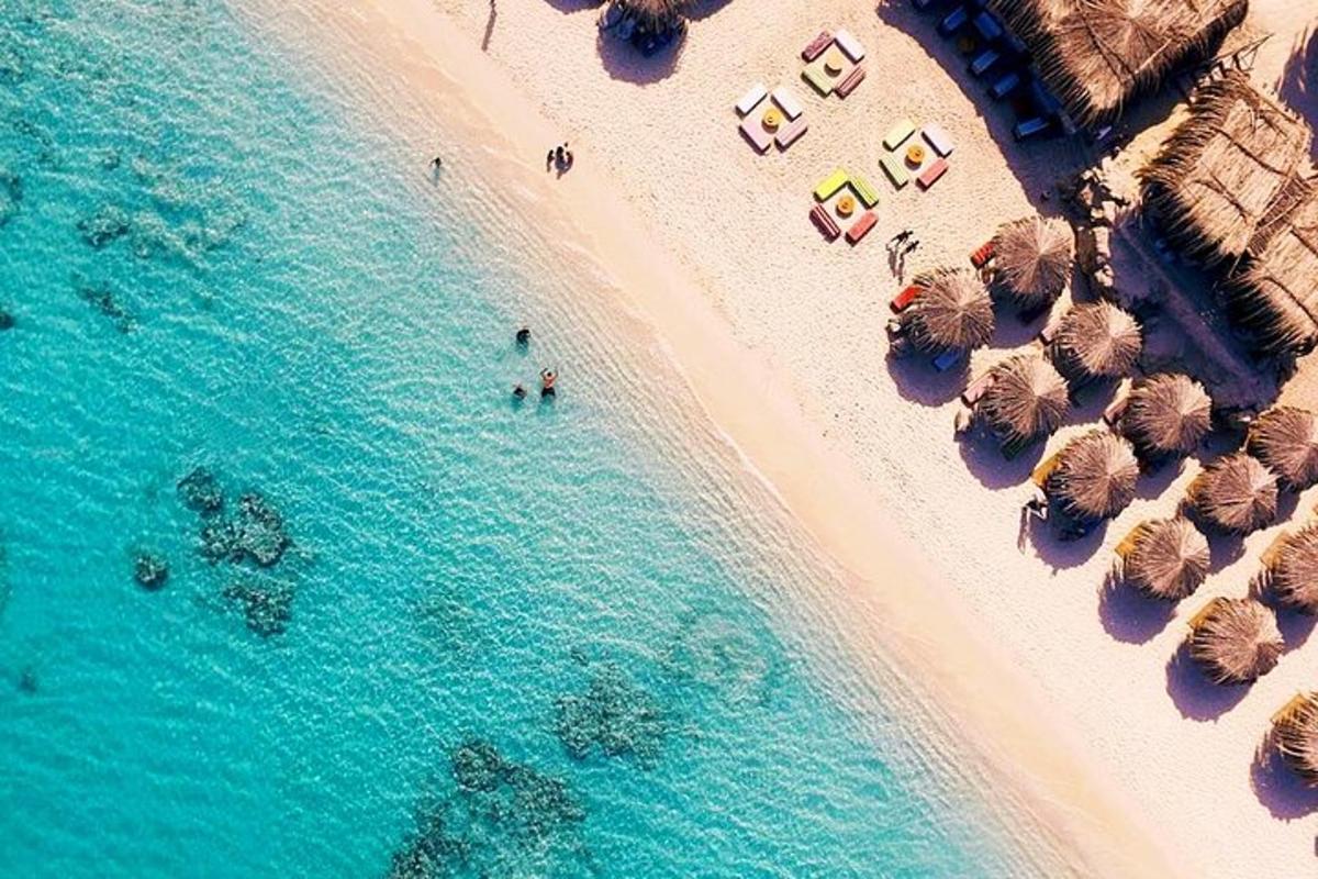 an overhead view of a beach with umbrellas and the ocean