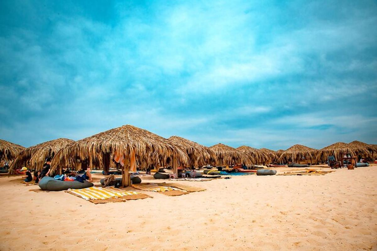 a group of straw umbrellas and lounge chairs on a beach