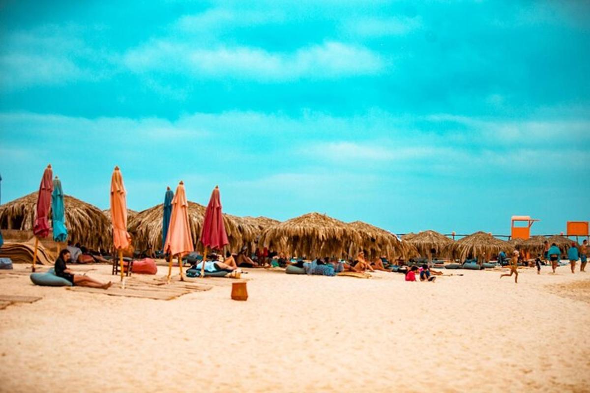 a beach with umbrellas and people on the sand