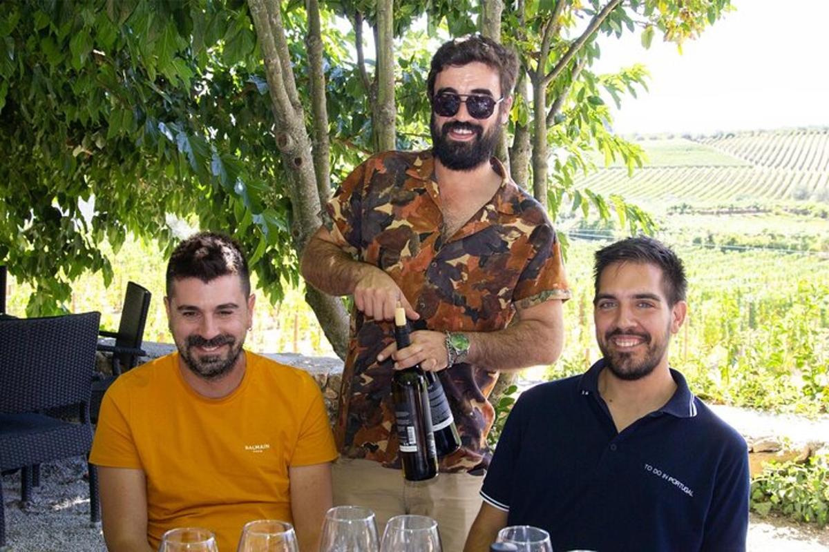 a man holding a bottle of wine with two men