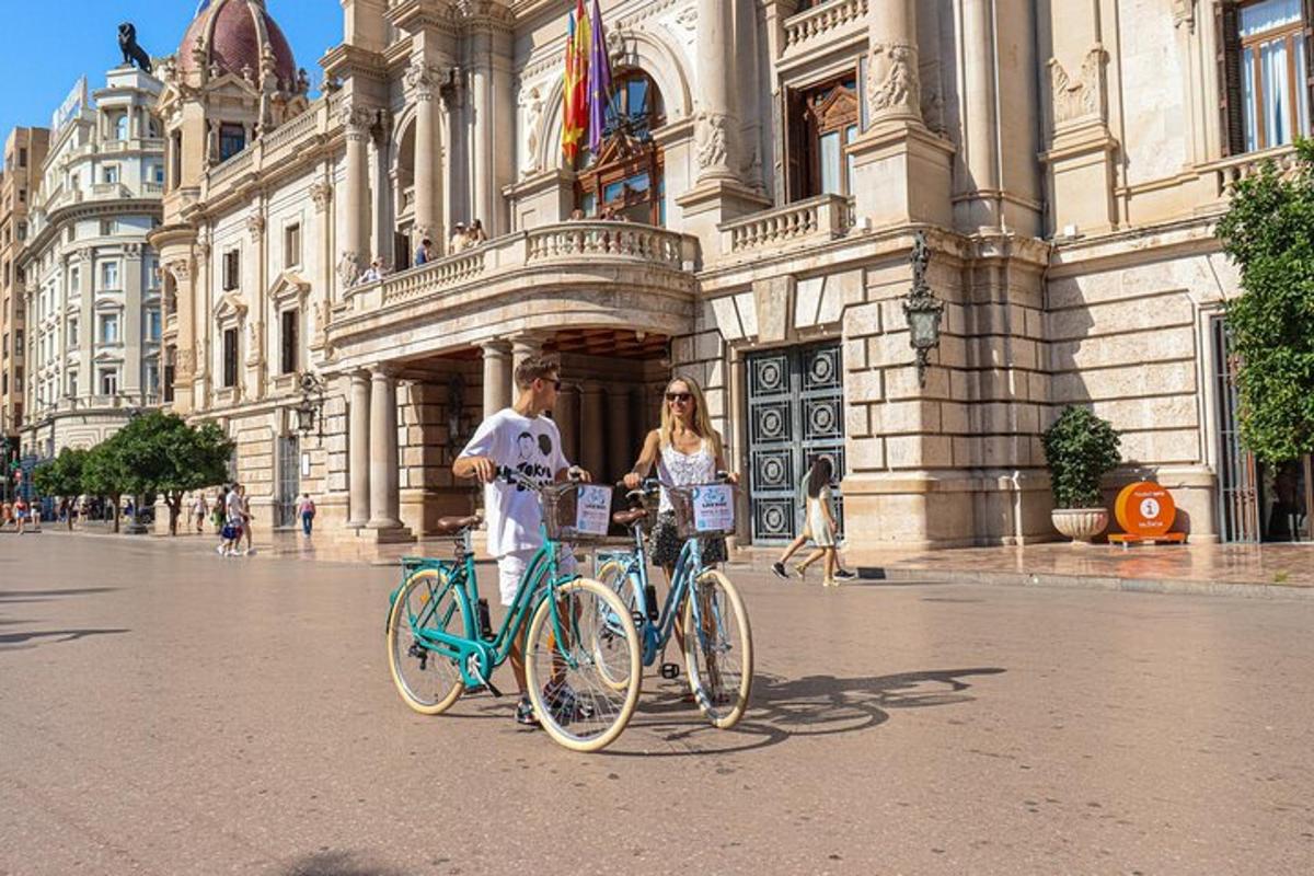 muž a žena stojící s koly před budovou