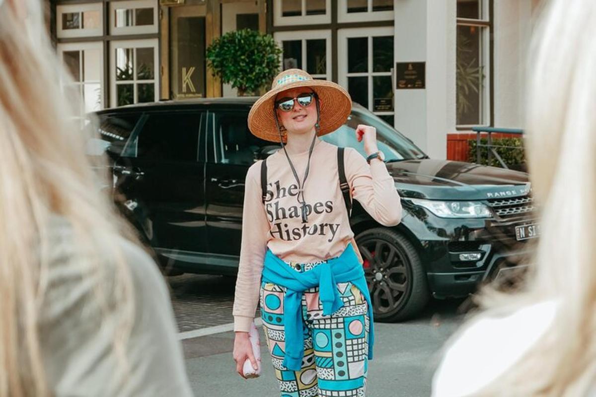 a woman wearing a hat standing in a street
