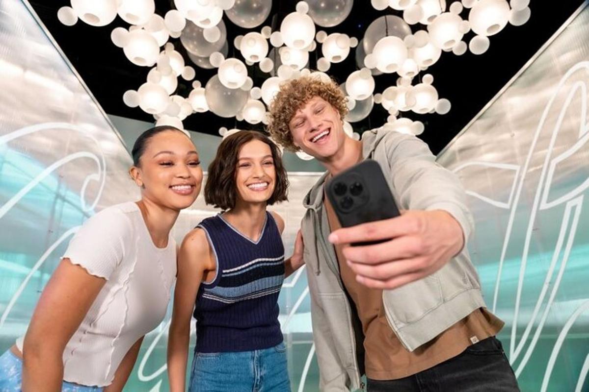 a group of three people taking a picture with a cell phone