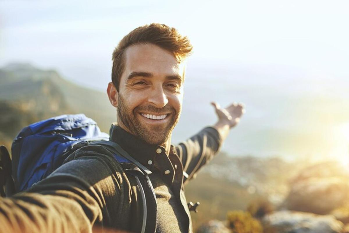 Un hombre con el brazo extendido en una montaña