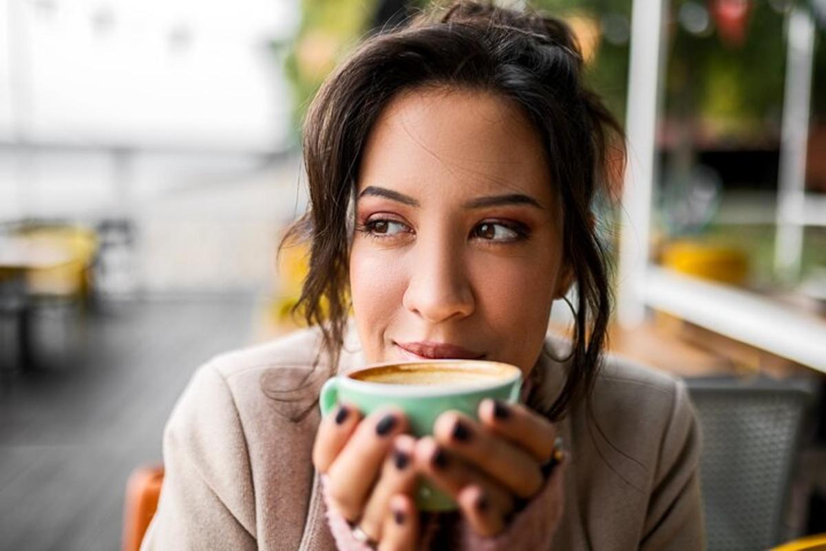 một người phụ nữ đang cầm một tách cà phê