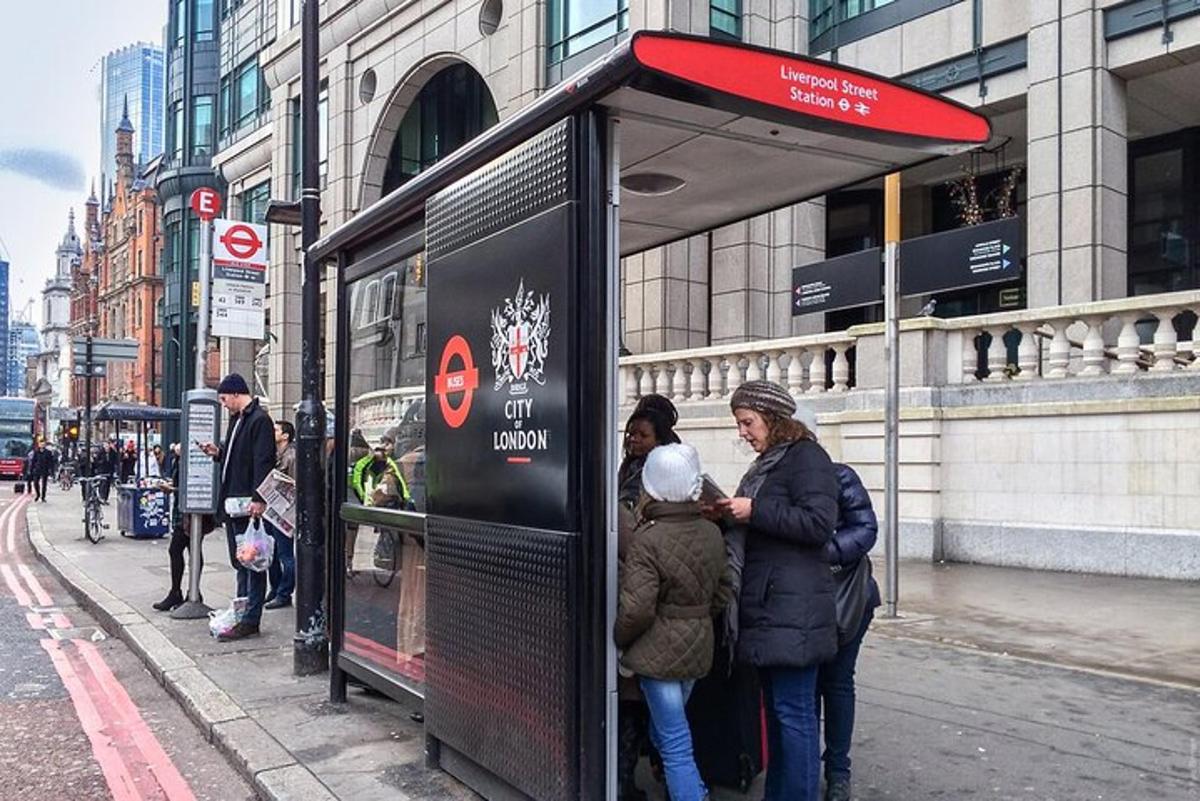 kona og barn standa við strætóskýli