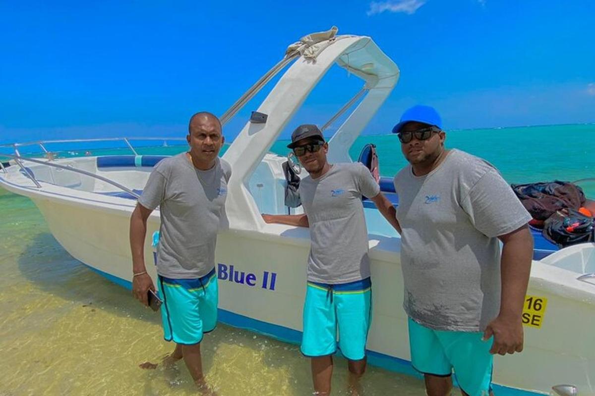 tre uomini in piedi accanto a una barca sulla spiaggia