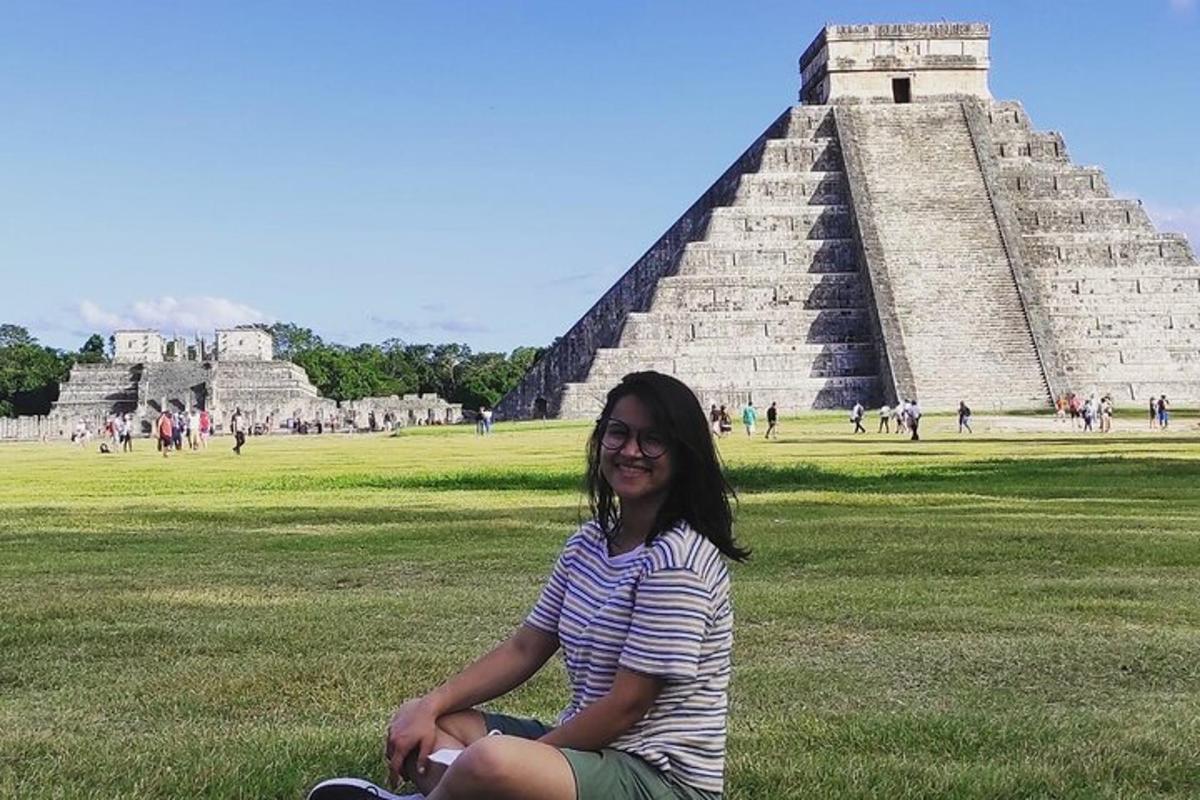 žena sedící před pyramidou