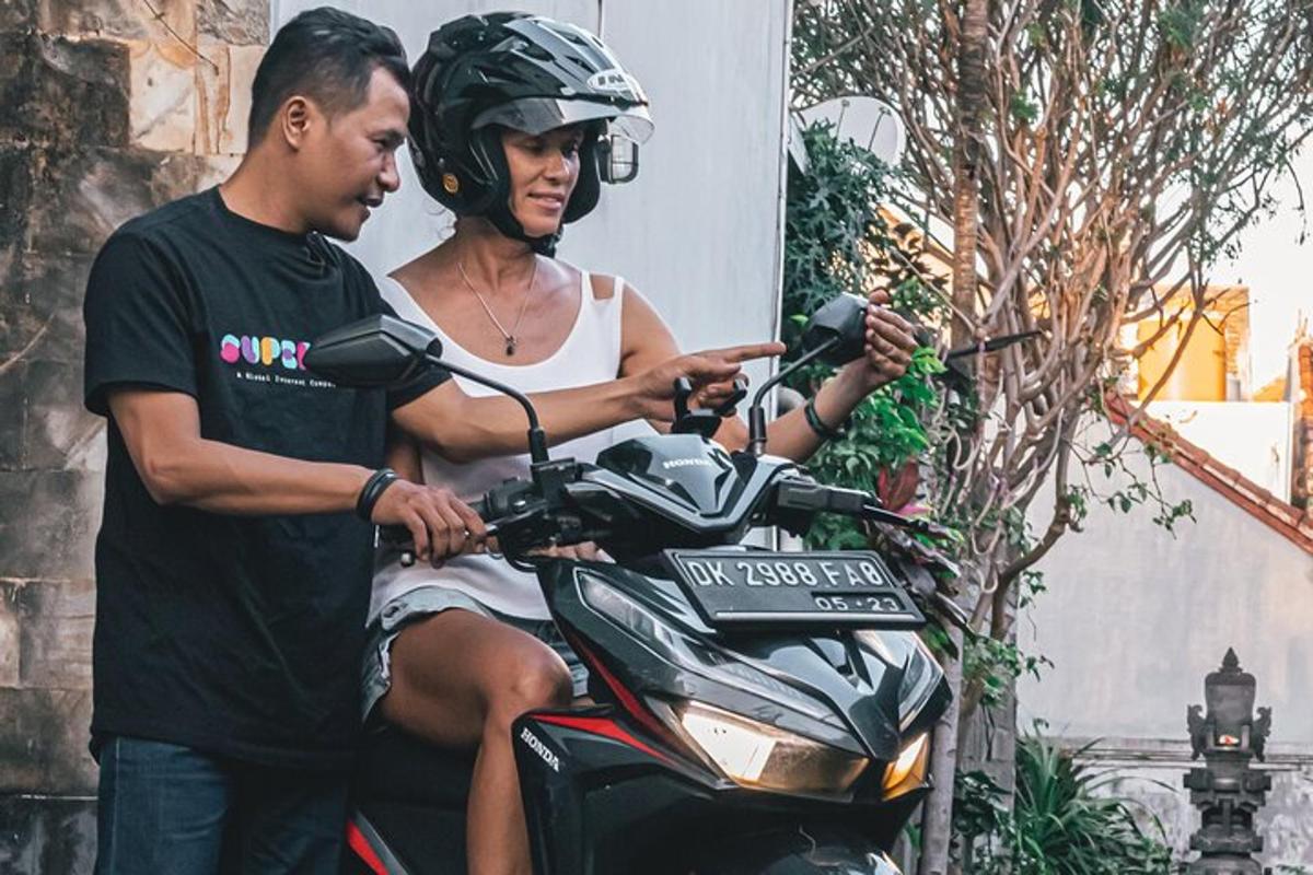 seorang lelaki dan seorang wanita duduk di atas motosikal