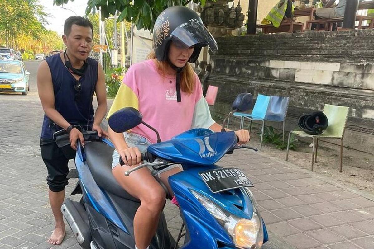 seorang wanita duduk di atas skuter dengan seorang lelaki