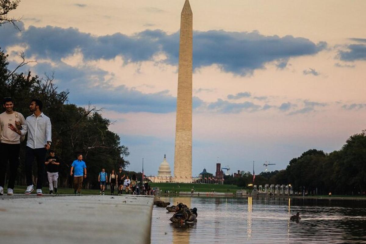 un gruppo di persone che camminano intorno al monumento a Washington