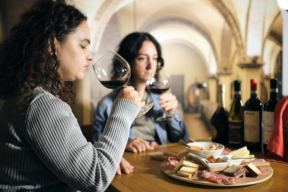due donne sedute a un tavolo che bevono vino