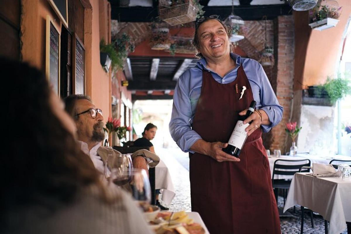 un uomo che tiene in mano una bottiglia di vino in un ristorante
