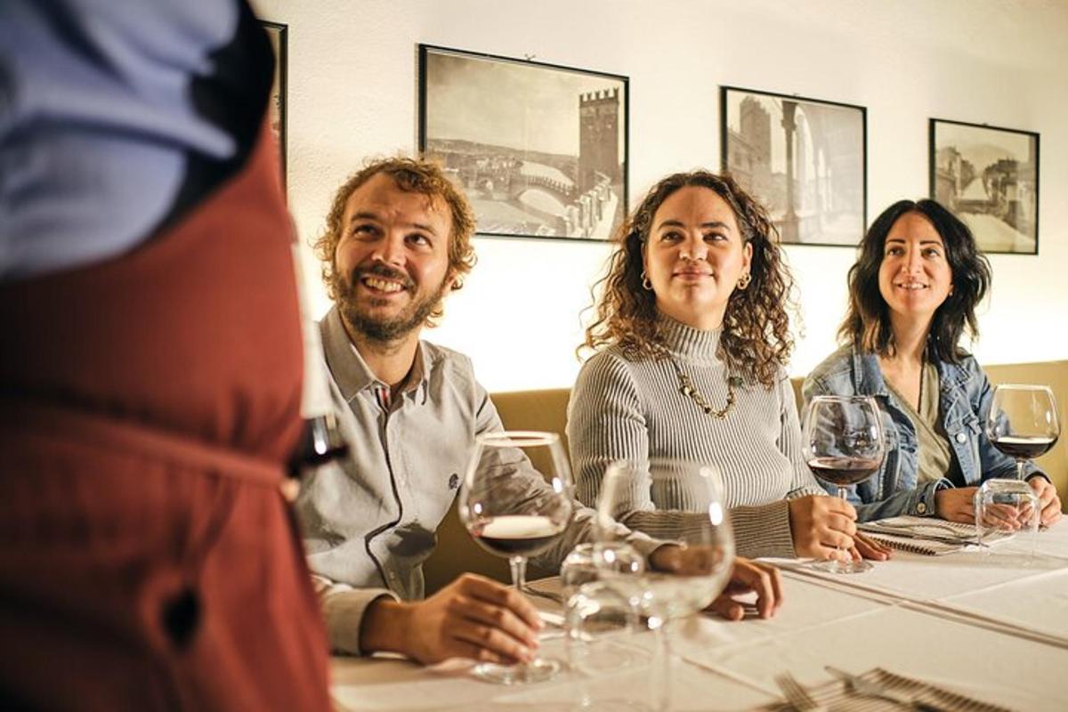 un gruppo di persone sedute a un tavolo con bicchieri di vino