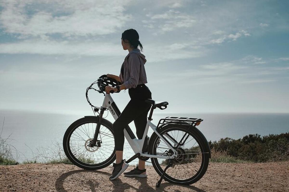 una donna sta andando in bicicletta sulla spiaggia